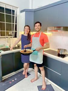 Un homme et une femme debout dans une cuisine dans l'établissement Green Homestay, à Hanoï