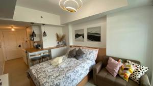 a bedroom with a bed and a couch and a desk at LeisureStay Studio - Azure North by THE BALI CORNER AT AZURE NORTH, Wave Pool and Man-made beach view in San Fernando