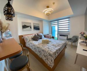 1 dormitorio con 1 cama, mesa y sillas en LeisureStay Studio @ Azure North, en San Fernando