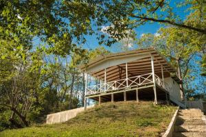 a wooden structure on top of a hill with trees at Blue Container La Paillote in Paquera