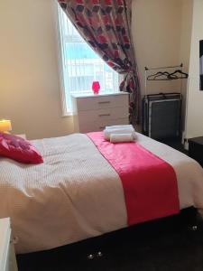 a bedroom with a bed with a red and white blanket at Blackpool Central Apartments 2 Bedroom FF in Blackpool