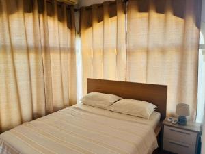 een bed in een slaapkamer met een raam met gordijnen bij The House in Casas Devesa