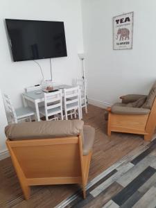 a living room with a table and chairs and a tv at Blackpool Central Apartments 2 Bedroom FF in Blackpool