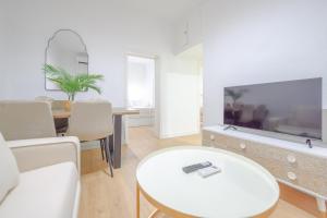 a living room with a large tv and a table at For You Rentals Bonito y coqueto apartamento en Vallecas CAU231D in Madrid