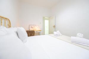 a white bedroom with two large white beds at For You Rentals Bonito y coqueto apartamento en Vallecas CAU231D in Madrid