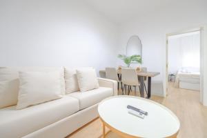 a white living room with a white couch and a table at For You Rentals Bonito y coqueto apartamento en Vallecas CAU231D in Madrid