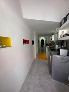 une cuisine aux murs blancs et un long couloir dans l'établissement Kefia 1, à Mesariá
