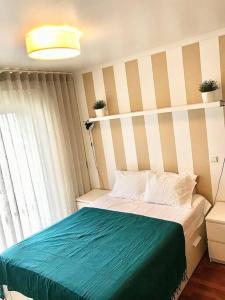 um quarto com uma cama com um cobertor azul em Gemini Apartment by AM no Funchal