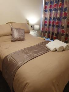 a bed with two towels sitting on top of it at Blackpool Central Apartments 2 Bedroom FF in Blackpool