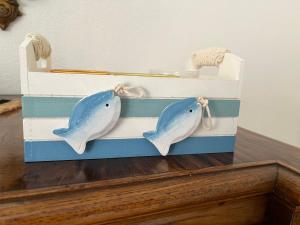 dos delfines en una caja de madera sobre una mesa en A CASA DEL CONSOLE, en Mondello