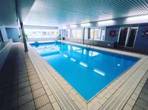 a large swimming pool in a large building at Studio Abee in Middelkerke