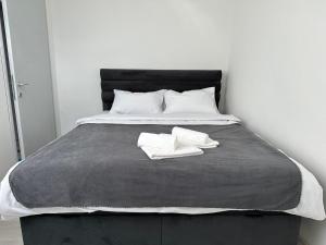 łóżko z dwoma białymi ręcznikami. w obiekcie Apartment Stari Aerodrom w mieście Podgorica