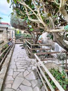 un chemin en pierre avec des arbres et une clôture dans l'établissement Charmant appart avec extérieur, à Aigues-Mortes