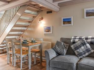 a living room with a table and a couch at Gable End Cottage in Ingleton