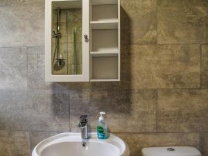 a bathroom with a sink and a mirror and a toilet at Gable End Cottage in Ingleton