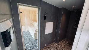 uma casa de banho com uma porta que conduz a um chuveiro e uma televisão em Rudnic Villa s Ap4 em Syfteland