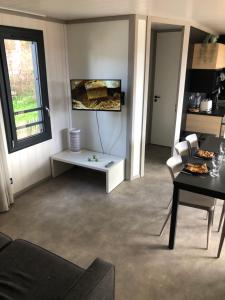 a living room with a table and chairs and a window at Cottage Jullouville récent l'Edune résidence vacances - plage 150 m -piscine - Wifi in Jullouville-les-Pins +17 photos