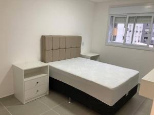 1 dormitorio con cama y ventana en Apartamento a 100m da beira-mar en Capão da Canoa