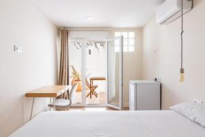 a bedroom with a bed and a table and a desk at Oasis Urbano Ciudad Expo in Mairena del Aljarafe