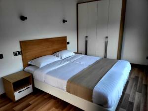 a bedroom with a large bed with a wooden headboard at Dili Dream Villa Resort in Dilijan