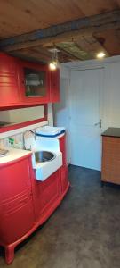 una cucina con armadi rossi e lavandino di Chambre privée bien desservie par les transports en commun a Colombes