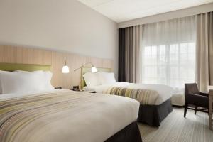 a hotel room with two beds and a window at Country Inn & Suites by Radisson, Jackson, TN in Jackson +13 photos