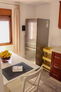una cocina con nevera y una mesa con un tazón de plátanos en Mercedes (E): Campo y playa. en Breña Baja