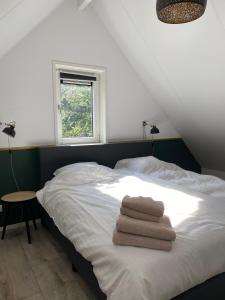 een slaapkamer met een bed met handdoeken erop bij Luxe Vakantiehuis Vosje op de Veluwe Nunspeet in Nunspeet