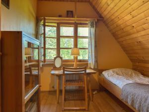 a bedroom with a desk and a bed and a window at Dom na Pawlikach in Rzepiska