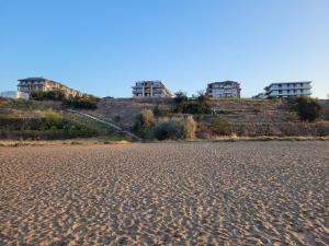 een strand met drie gebouwen op de top van een heuvel bij Bayview B32 - Burgas Beach Resort in Boergas