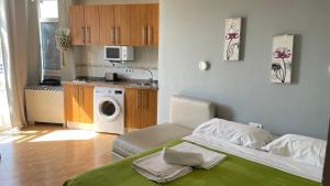 ベナルマデナにあるBenalmadena ,apartamento-Estudio primera Línea de Playaのベッド1台付きの部屋、洗濯機付きのキッチン