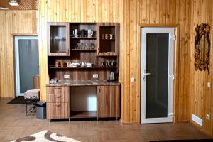 una cucina con pareti in legno e bancone con lavandino di Вілія a Lomacineţi