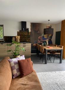 een woonkamer met een bank en een tafel bij Luxe Vakantiehuis Vosje op de Veluwe Nunspeet in Nunspeet