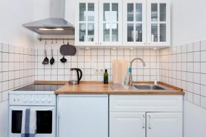 a kitchen with white cabinets and a sink at Brüsseler Straße 39 in Berlin