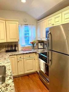 a kitchen with white cabinets and a stainless steel refrigerator at Mt Holly Home With Playground Grill Basketball, free cancel in Mount Holly