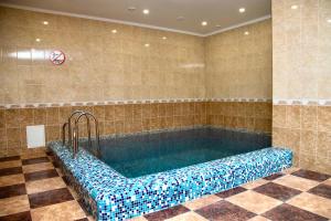 een zwembad in een kamer met een tegelvloer bij Вілія in Lomacineţi