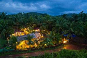 an aerial view of a resort with palm trees at night at Whoopers Party Hostel, Palolem in Canacona