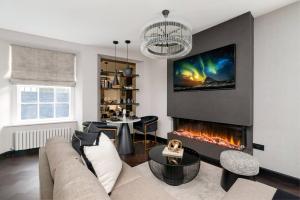 a living room with a couch and a fireplace at Luxury West End Oasis - Lux Spa Bath - Romantic in Edinburgh
