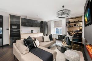 a living room with a couch and a kitchen at Luxury West End Oasis - Lux Spa Bath - Romantic in Edinburgh