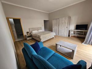 salon z niebieską kanapą i łóżkiem w obiekcie Beachfront Coziness w mieście Flic-en-Flac