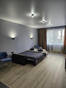 1 dormitorio con 1 cama, 1 silla y 1 ventana en Premium apartments 2, en Leópolis