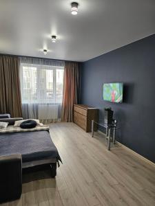 1 dormitorio con 1 cama y TV en la pared en Premium apartments 2, en Leópolis