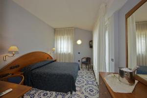 Pokój hotelowy z łóżkiem i biurkiem w obiekcie Hotel Parco w mieście Castellammare di Stabia