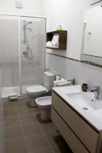 a bathroom with a toilet, sink, and bathtub at I Santi Coronati in Syracuse