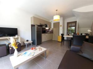 ein Wohnzimmer mit Couch und Tisch und eine Küche in der Unterkunft Nid d'Aven Charmante maison, piscine de février à octobre 1-6p dans résidence in Pont-Aven