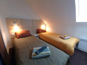 2 Betten in einem Hotelzimmer mit Fernbedienung in der Unterkunft Nid d'Aven Charmante maison, piscine de février à octobre 1-6p dans résidence in Pont-Aven + 19 Fotos