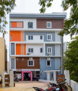 ein Mehrfamilienhaus mit einem Motorrad, das davor geparkt ist in der Unterkunft Hotel Elite Park in Tirupati