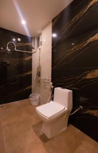 ein Badezimmer mit einem weißen WC und einer Dusche in der Unterkunft Hotel Elite Park in Tirupati