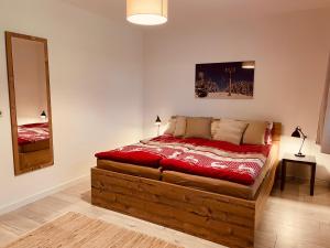 een slaapkamer met een houten bed en een spiegel bij Apartment an der Wurmbergseilbahn 4 in Braunlage