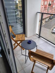 a balcony with a table and two chairs and a window at Centrum Apartament z parkingiem in Szczecin